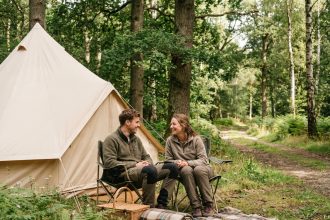 Jeune couple assis dans la nature en camping