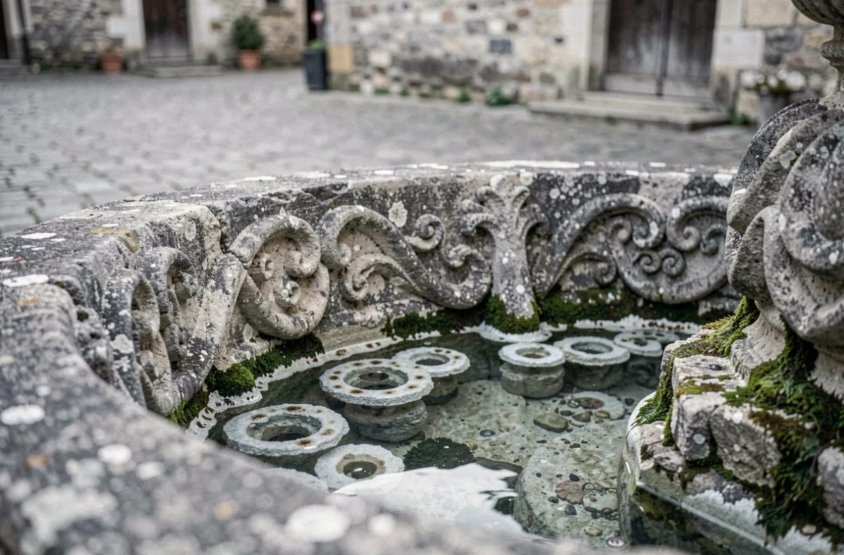 Détail sculpté du bassin de la fontaine d'Arlette à Falaise avec dépôts minéraux et patine ancienne