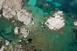 aerial view of white and gray rocks on body of water during daytime