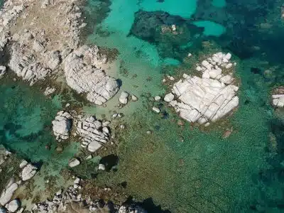 aerial view of white and gray rocks on body of water during daytime