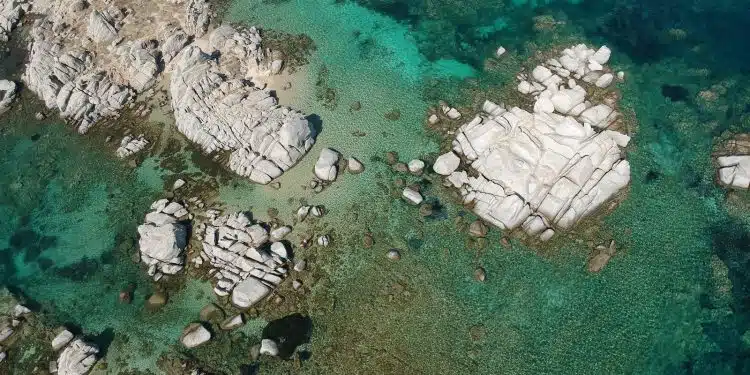 aerial view of white and gray rocks on body of water during daytime